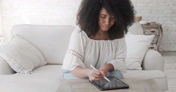 Artista independiente femenina negra usando tableta digital con lápiz electrónico para crear arte criptográfico o ilustraciones de dibujo. — Vídeo de stock