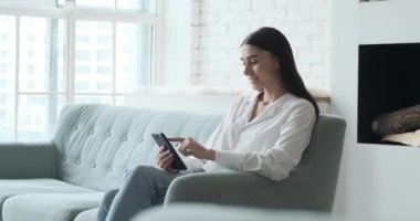 Gülümseyen genç kadın akıllı telefon uygulaması kullanarak olumlu haberler okumaktan zevk alıyor.