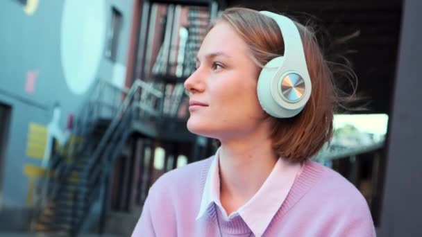 Меланхоличная студентка в наушниках слушает музыку — стоковое видео