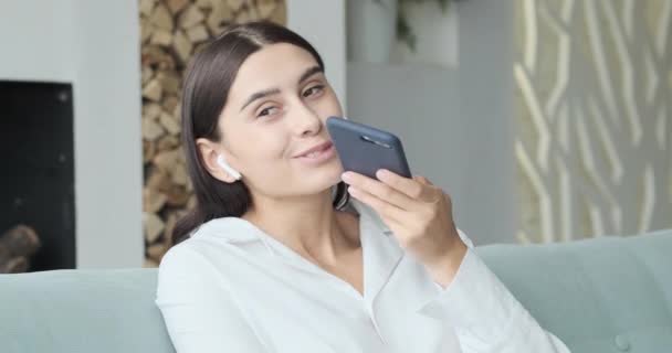 Młoda uśmiechnięta kobieta nagrywa wiadomość audio do przyjaciela — Wideo stockowe