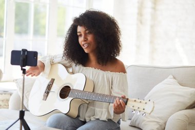 Gitar çalan ve özel ders kaydı yapan kadın siyah vlogger etkileyicisi,