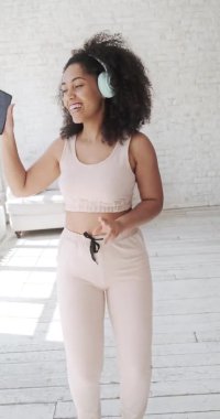 Kulaklık takan mutlu bir melez kadın hareket etmekten hoşlanır..