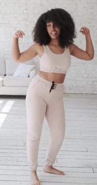 Modayı takip eden mutlu siyah ırk kadın vlogger müzik dinliyor, dans ediyor
