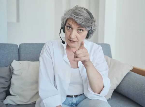 Mujer mayor en la transmisión de auriculares en línea en una red social y se comunica con sus suscriptores — Foto de Stock