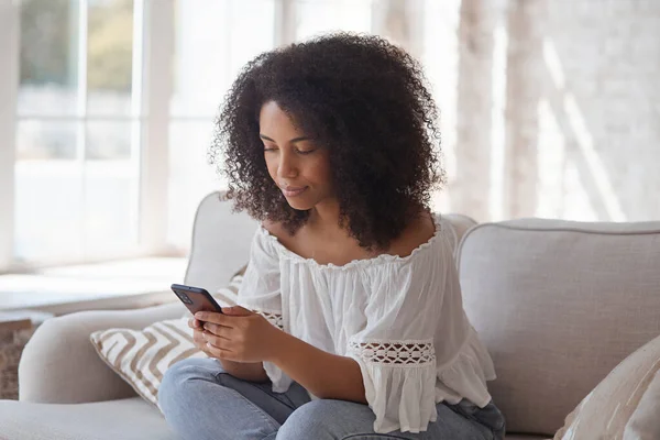 Χαμογελώντας afro αμερικανική γυναίκα απολαμβάνοντας τη χρήση εφαρμογή smartphone ανάγνωση θετικά νέα — Φωτογραφία Αρχείου