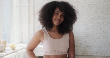 Geniş beyaz dişli gülüşü ve şık bir dairede portresi olan çok çekici, çift ırklı bir kadın..