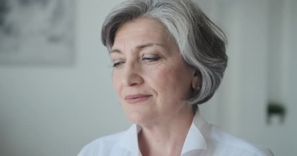 Une femme âgée confiante et instruite directrice générale se tient dans un milieu de travail contemporain lumineux et semble sérieuse — Video