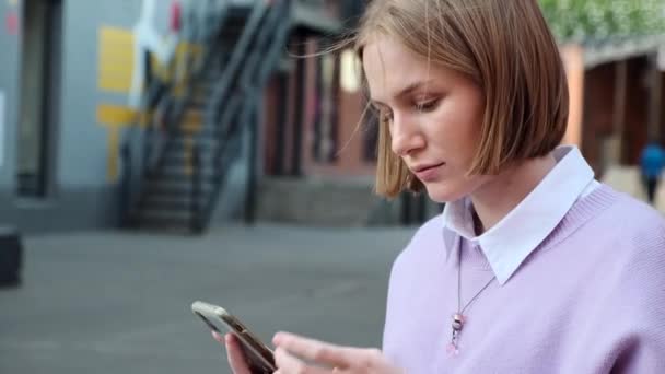 Senhora loira com tipos de cabelo curto no telefone preto na rua — Vídeo de Stock