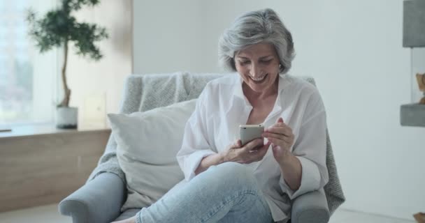 Mobile dipendente anziani donna matura utilizzare smartphone tutti i tempi a casa — Video Stock