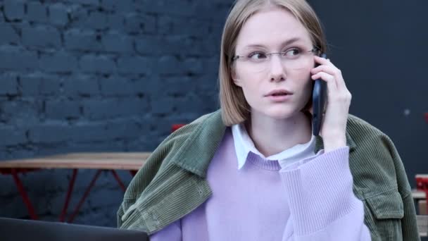 Koncentreret korthåret dame taler på sort smartphone – Stock-video