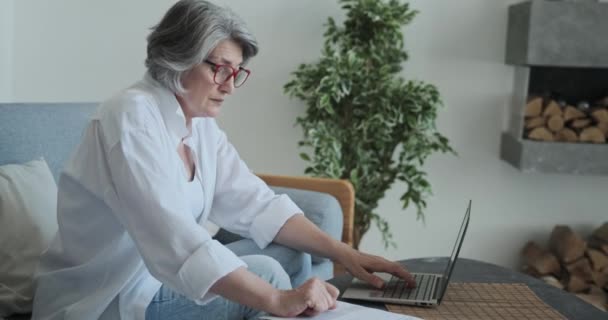 Przemyślana, starsza, poważna bizneswoman analizuje raport finansowy firmy. — Wideo stockowe