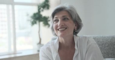 Neşeli, başarılı, gri saçlı, yaşlı, emekli büyükanne rahat bir şekilde poz veriyor.