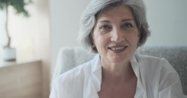 Porträt einer glücklichen Seniorin in einer hellen, komfortablen Wohnung. — Stockvideo