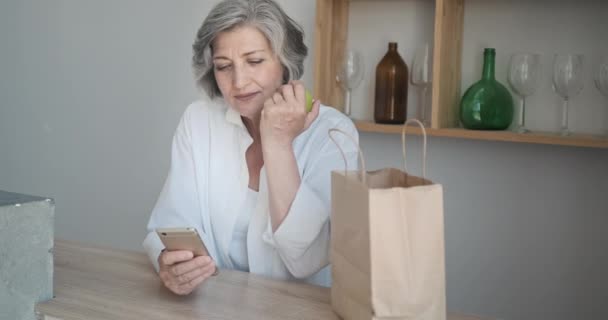 Mujer mayor recibió entrega de comestibles en bolsa de papel. Pedido en línea de frutas y verduras — Vídeos de Stock