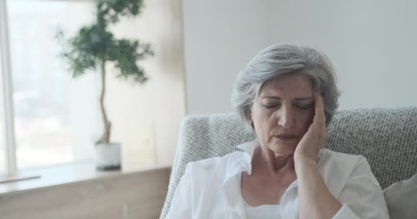 Oudere oudere oudere vrouw met migraine en hoofdpijn, geheugenverlies en slaapproblemen. — Stockvideo