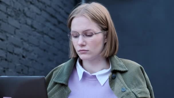 La giovane donna freelance si siede sulla terrazza del caffè al computer portatile — Video Stock