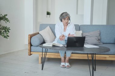 Kıdemli kadın öğretmen öğrencilere ve anaokullarına davranış kurallarını izah eder ve onlara uzaktan öğretir..