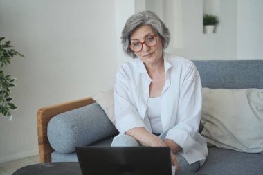 Olumlu gülümseyen büyükanne çocuklarıyla ve torunlarıyla sosyal medyada iletişim kuruyor.