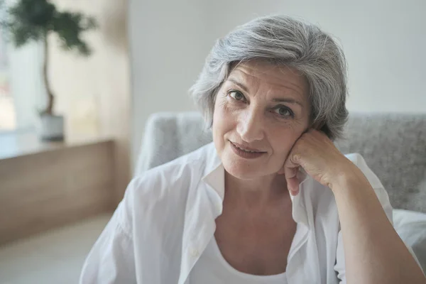 Vrolijk succesvol grijs harig senior gepensioneerde oma genieten van comfortabel poseren in gezellige kamer — Stockfoto