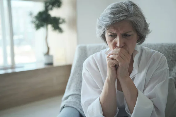 Een bedachtzame oudere vrouw, alleen thuis gezien een gevaarlijk gezondheidsprobleem.. — Stockfoto