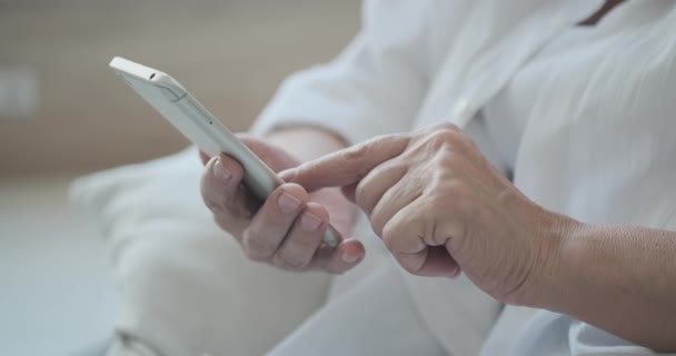 El uso de aplicaciones de teléfono móvil, cerca de una mujer anciana madura. — Vídeos de Stock