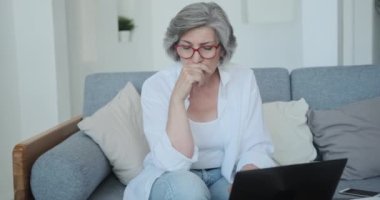 Sosyal ağda yazı yazmak için dizüstü bilgisayar kullanan düşünceli son sınıf kadın blogcu