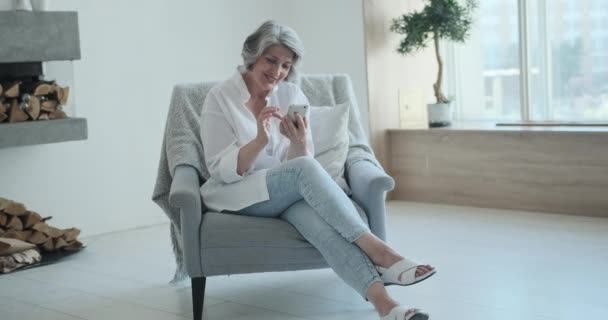 Entspannte ältere Frau nutzt Handy-Apps — Stockvideo