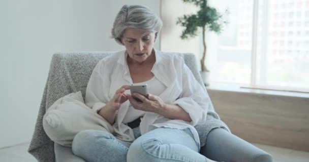 Uvolněné starší ženy objevující mobilní telefony aplikace chatování na sociálních sítích — Stock video