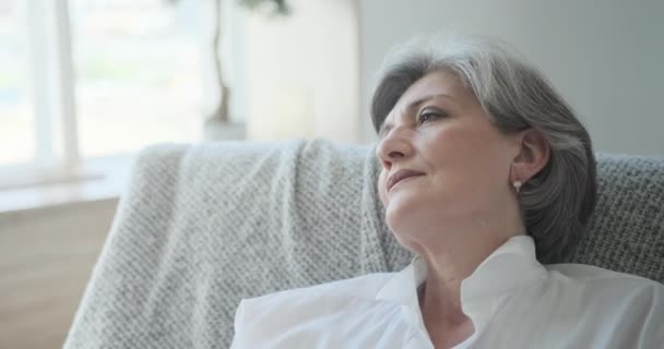 Een oudere vrouw sluimert in een comfortabele stoel, ontspant en rust haar energie — Stockvideo