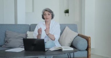 Uzaktan öğrenme için laptop kamerasını kullanırken son sınıf bayan öğretmen konsantre oluyor..