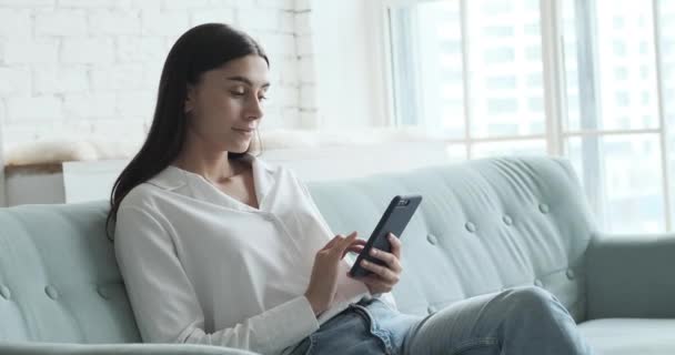 Happy žena pomocí smartphonu, těší chatu s přítelem nebo kolegy a číst dobré zprávy, — Stock video