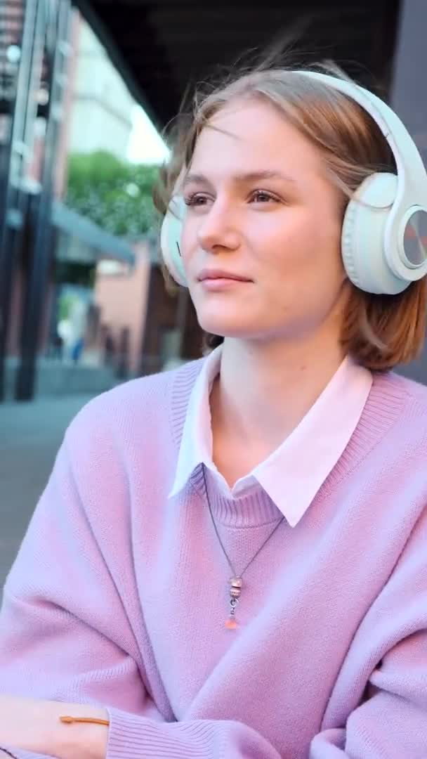 Melancólica estudiante de auriculares escucha música — Vídeos de Stock