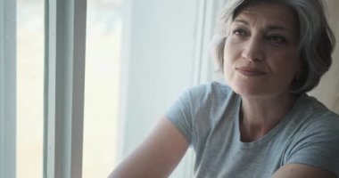 Mutlu ve başarılı bir kadın lüks bir evin penceresinde oturur.