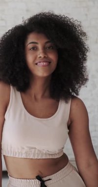 Neşeli genç melez kadın vlogger öğrencisi yalnız dans ediyor.