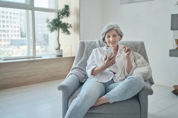 Lachende 60s oudere oudere middelbare leeftijd volwassen dame genieten van mobiele voor video conferentie bellen virtuele familie — Stockfoto