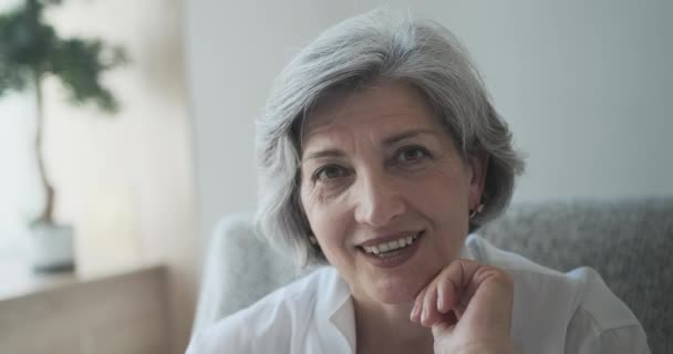 Fröhliche Seniorin mittleren Alters sitzt allein in Wohnung — Stockvideo