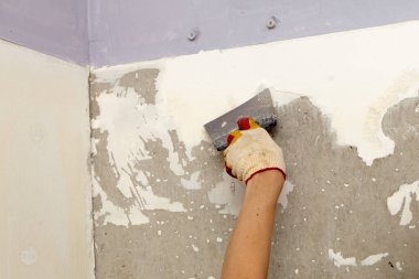 Duvarı onar. Duvarı spatulayla kaplayın. İç yapı ve bitirme işleri. 