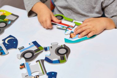 Çocuk bulmacalarla oynuyor. Oğlan odasında oyun oynuyor. Çocuklar için eğitici mantık oyuncakları