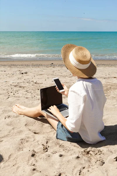 Ung Kvinna Som Använder Bärbar Dator Och Håller Mobiltelefon Stranden — Stockfoto