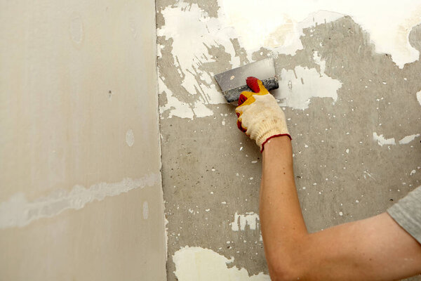 Почини стену. Оштукатури стену лопаткой. Внутреннее строительство и отделочные работы. 