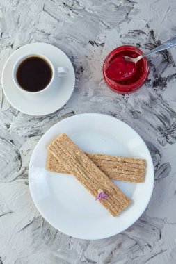 Kahvaltı için reçelli çıtır ekmek ve gri bir arka plan. Köpüklü bir kavanoz taze bal bir fincan kahvenin yanında. En az kalori. uygun beslenme