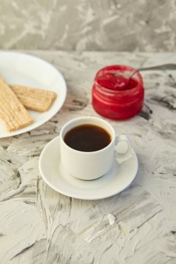 Kahvaltı için reçelli çıtır ekmek ve gri bir arka plan. Köpüklü bir kavanoz taze bal bir fincan kahvenin yanında. En az kalori. uygun beslenme