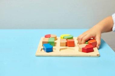 Çocuk bir tasnif makinesi topluyor. Çocuklar için eğitici mantık oyuncakları. Çocukların elleri, yakın plan. Çocuk Gelişimi için Montessori Oyunları. Beyaz arkaplanda çok renkli mantık sıralayıcı.