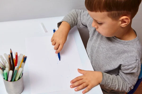 可爱的金发小男孩在家里画彩色铅笔 在白桌上画画 — 图库照片