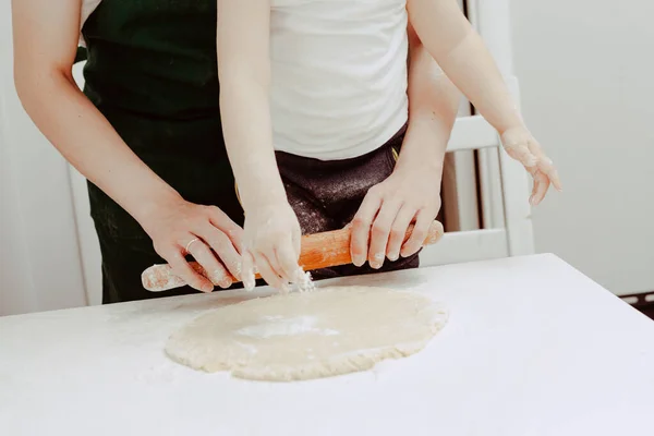Happy family in the kitchen. Dad and son preparing the dough, bake cookies. Casual lifestyle in home interior, pretty child, holiday concept, rolling pin, coockie cutters and dough.