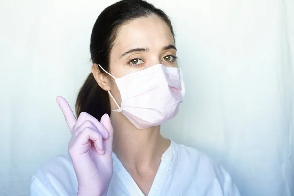 一个戴手套和防护面具的女人站在浅色的背景上 身穿白色夹克 抑制头孢病毒的概念 — 图库照片