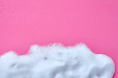 Köpük köpükler ve pembe arka planda bir kalıp sabun. Sabundan beyaz köpük, pembe arka planda şampuan ya da temizleyici seçici odaklı temizlik hizmeti