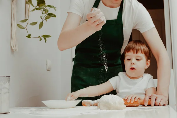 Happy family in the kitchen. Dad and son preparing the dough, bake cookies. Casual lifestyle in home interior, pretty child, holiday concept, rolling pin, coockie cutters and dough.