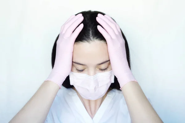 마스크를 배경에 장갑을 여자는 손으로 머리를 코로나 바이러스로 스트레스 — 스톡 사진