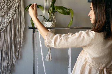 Kız makrome örüyor. Boho dekoru dokuma sürecinde. El yapımı.